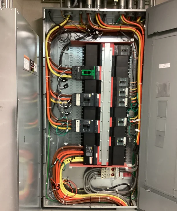 Licensed electrician installing electrical panelboard in Phoenix Arizona commercial facility